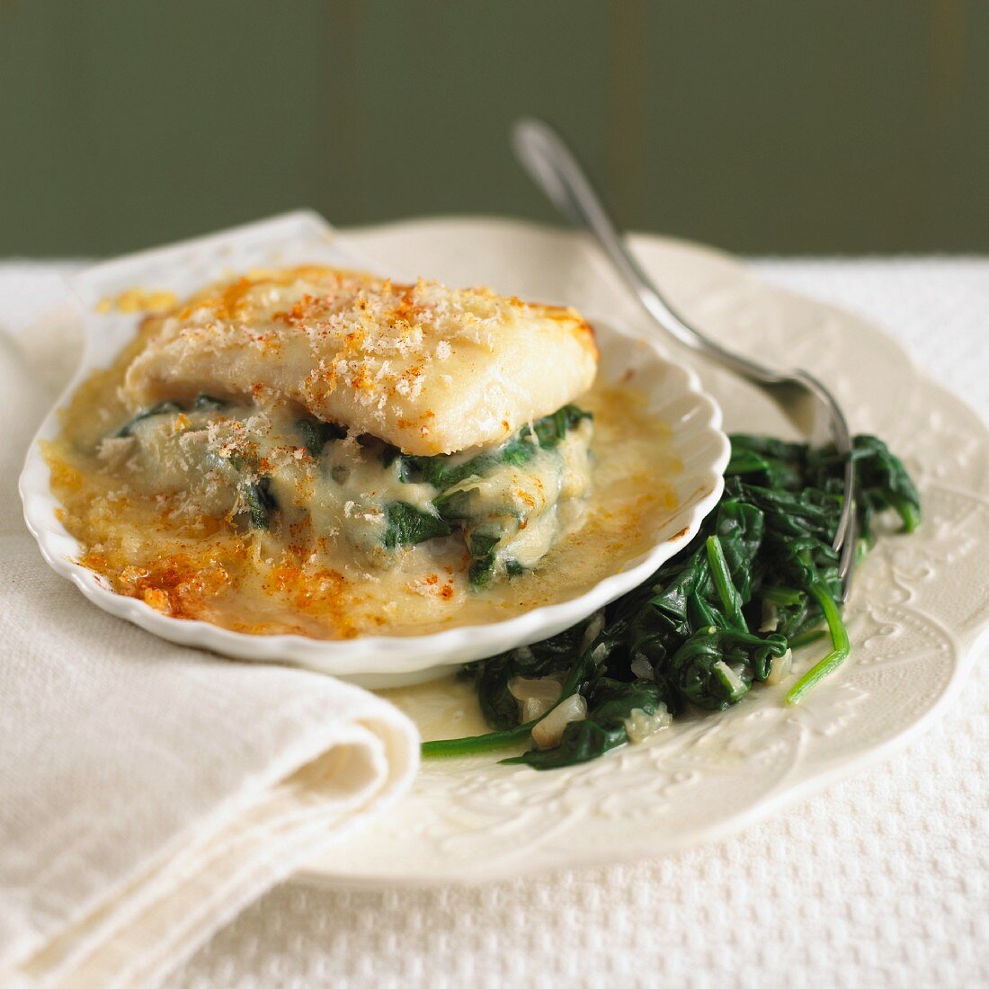 Haddock baked with cheese, served with spinach