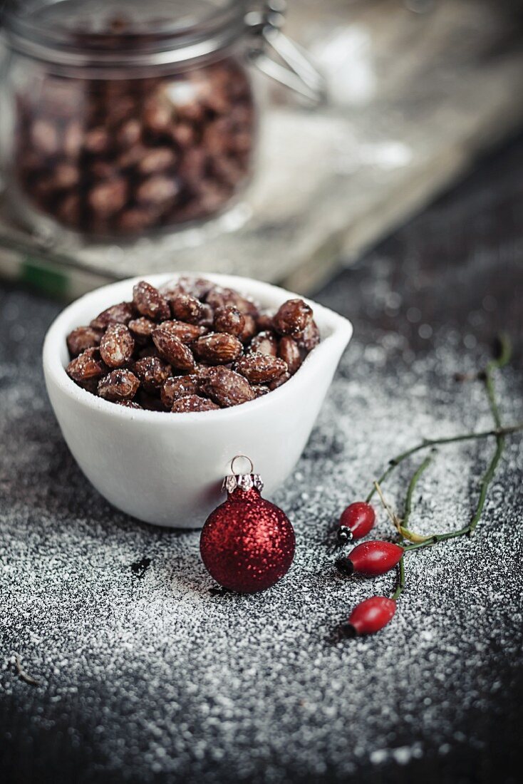 Caramelised almonds in a white bowl with Christmas decoration