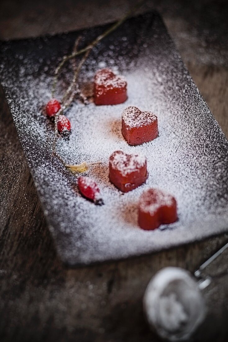 Heart-shaped quince bread on a plate with icing sugar