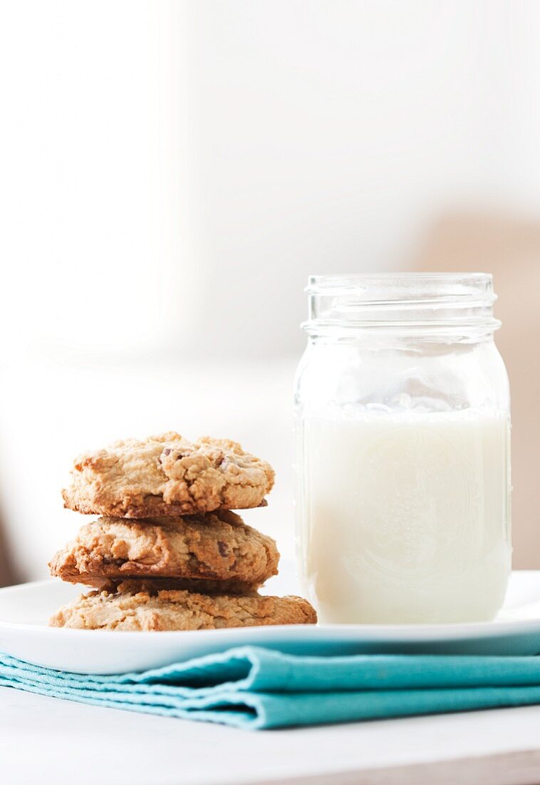 A Stack of Homemade Chocolate Chip Cookies with Milk in a Mason Jar
