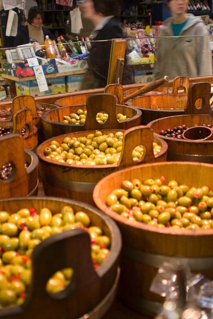 Eingelegte Oliven in Holzkfässern auf Markt