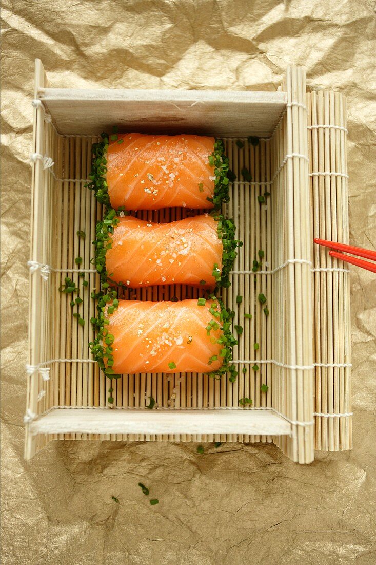 Salmon sushi in a basket made from bamboo mats