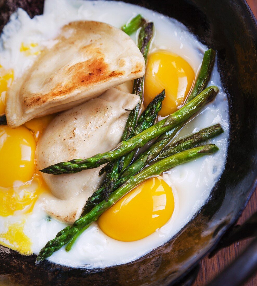 Fried eggs with asparagus and ravioli
