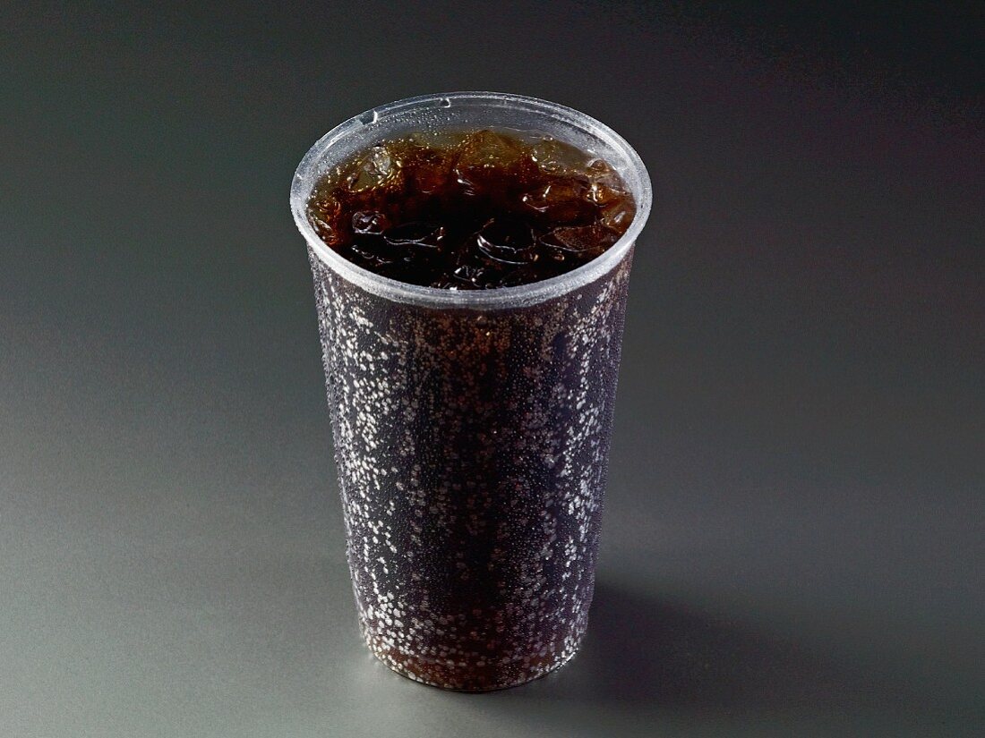 Cola with ice cubes in a plastic cup