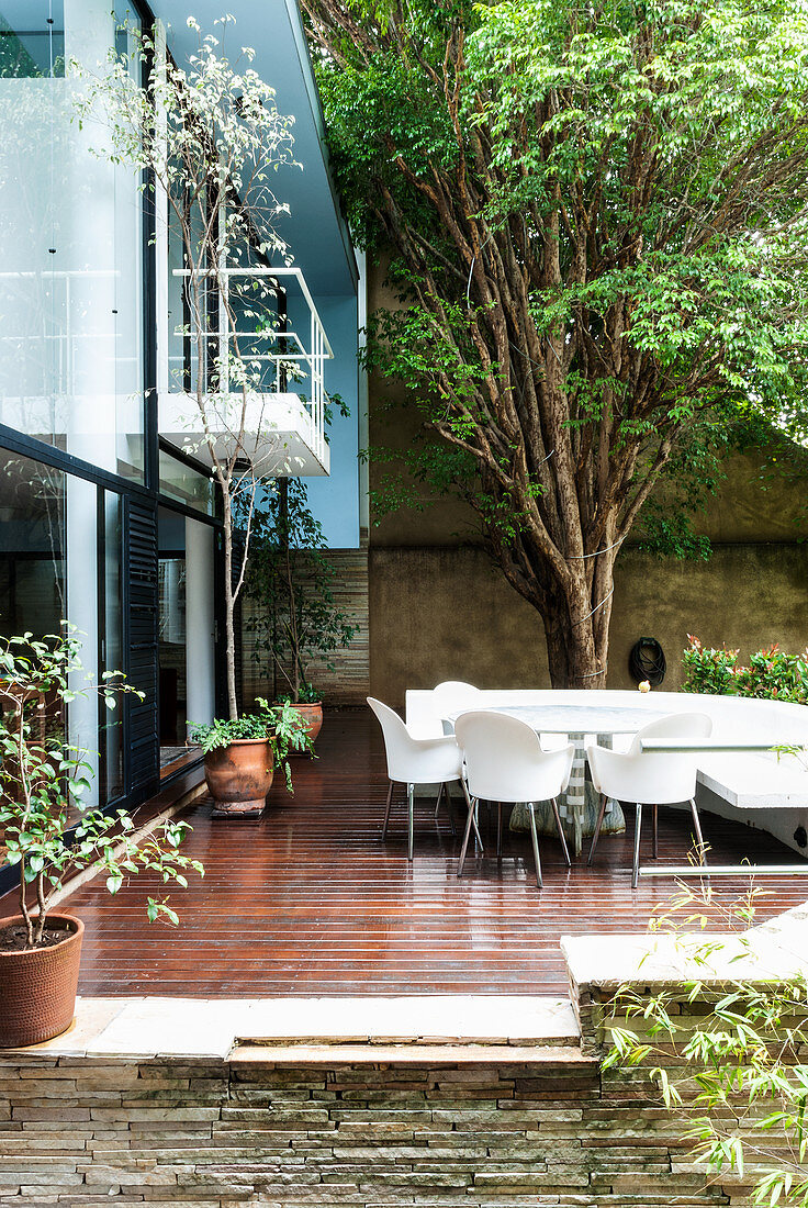 Holzterrasse mit Sitzplatz im Innenhof eines lichtdurchfluteten Wohnhauses in Sao Paulo