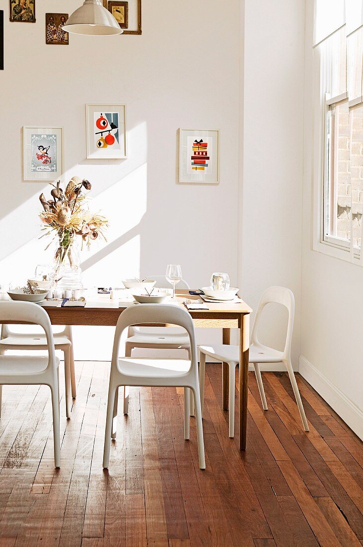 Light falls into the simple dining room with wooden floor