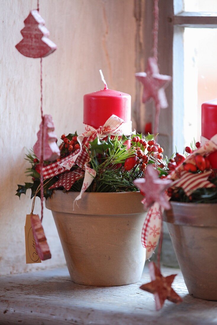 Rustic Christmas arrangement of twigs and candles in plant pots