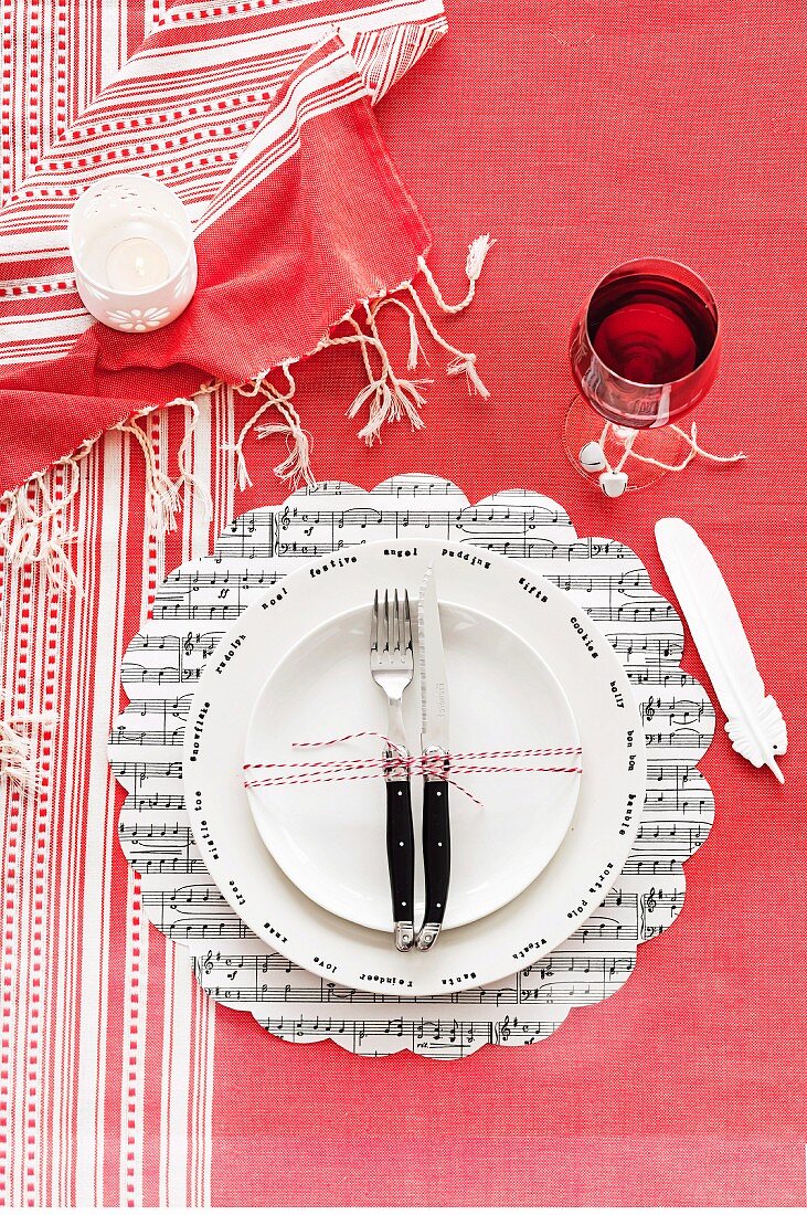 weiße Teller auf Tischset mit Musiknoten und rot-weiß gestreifter Tischdecke arrangiert