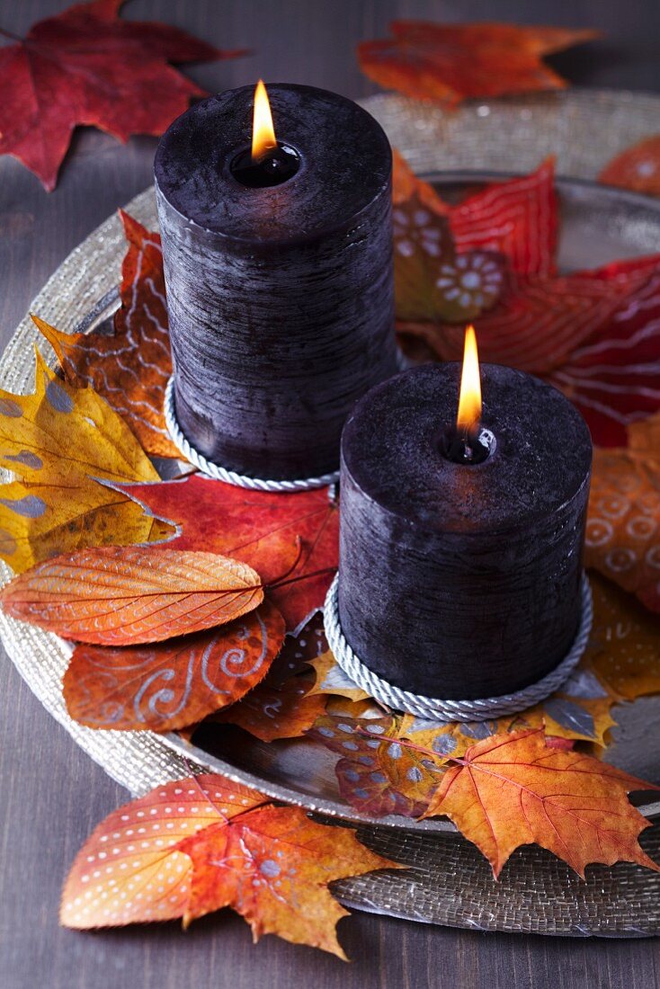 Tray of candles and painted autumn leaves