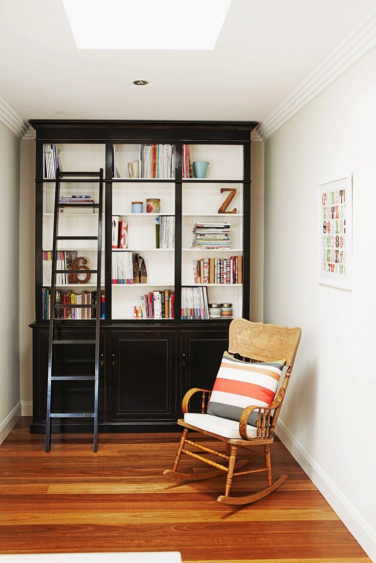 Cozy reading area with rocking chair and black retro bookcase