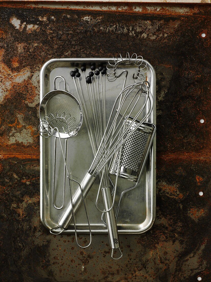 Assorted kitchen utensils on a metal tray
