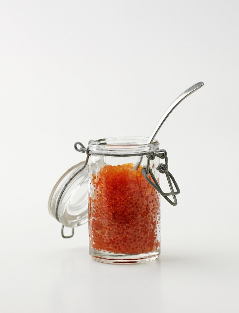 Keta caviar in a jar with a spoon