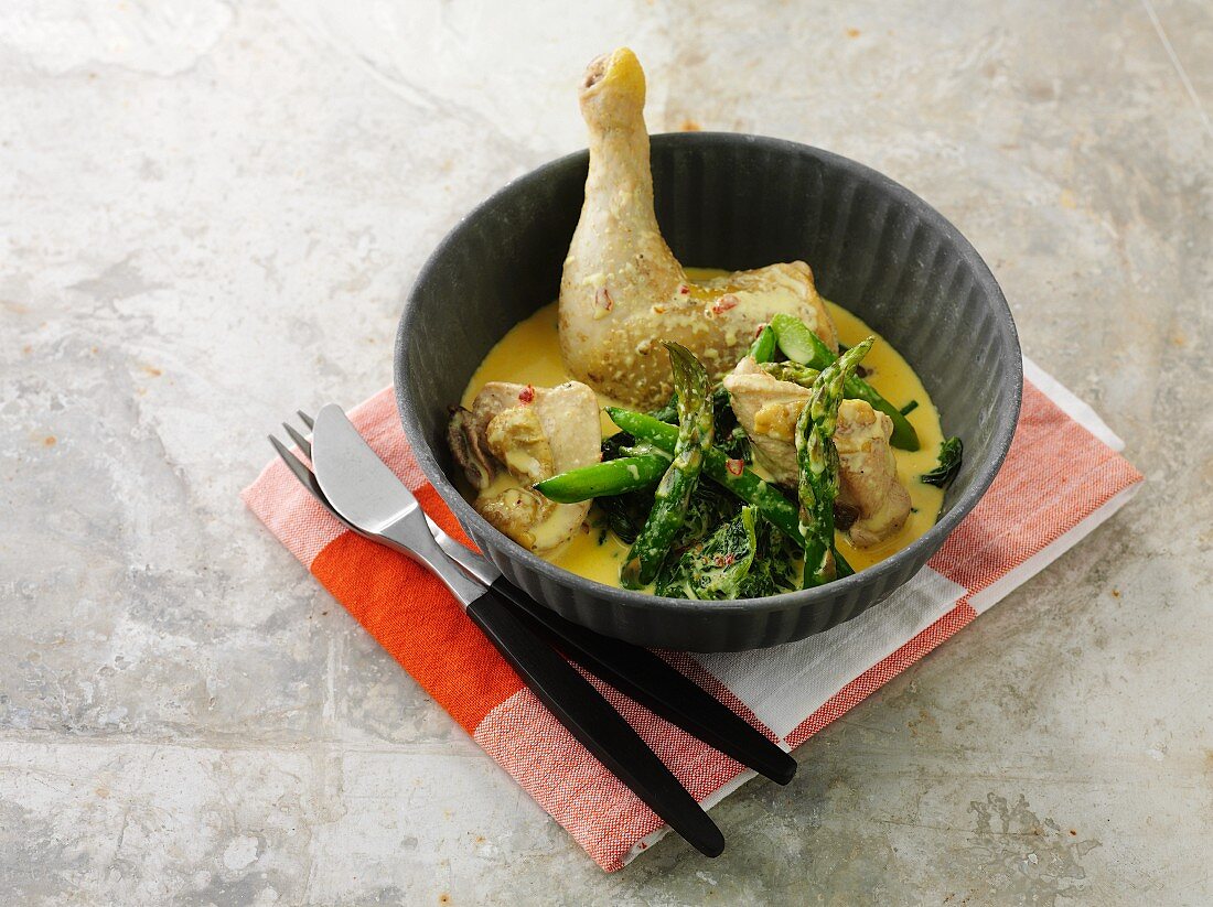Chicken leg with green asparagus in curry sauce