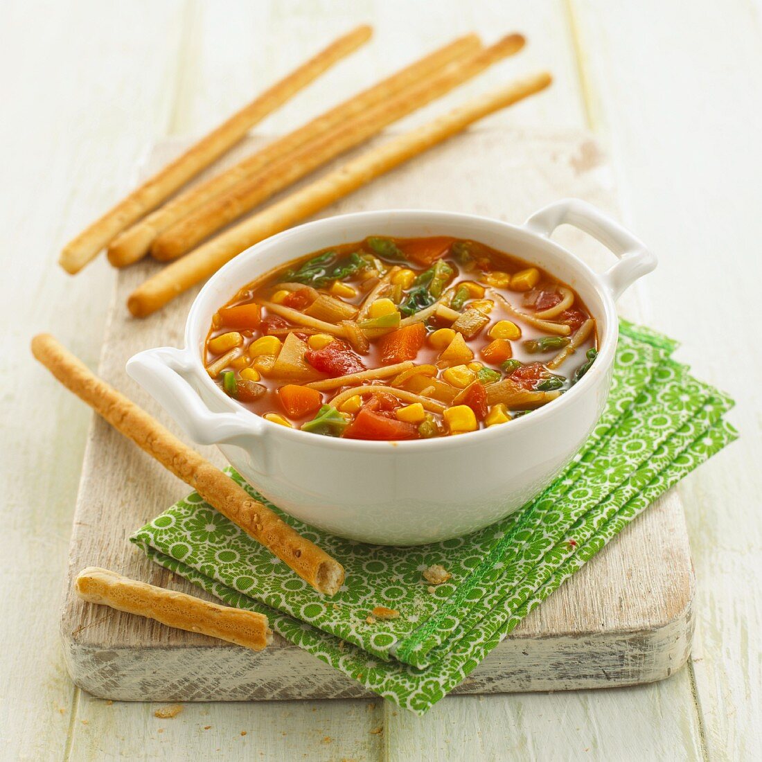 Vegetable stew with pasta and breadsticks