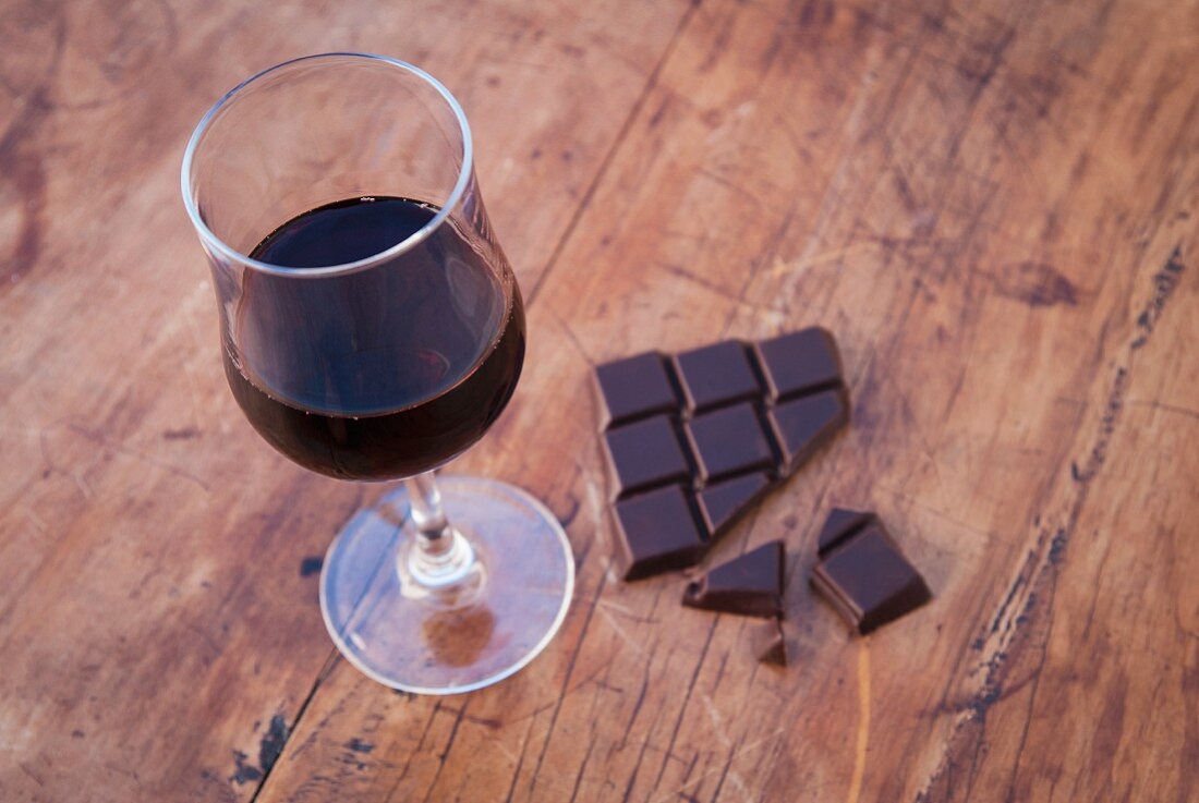 Still life featuring dark chocolate and a glass of red wine