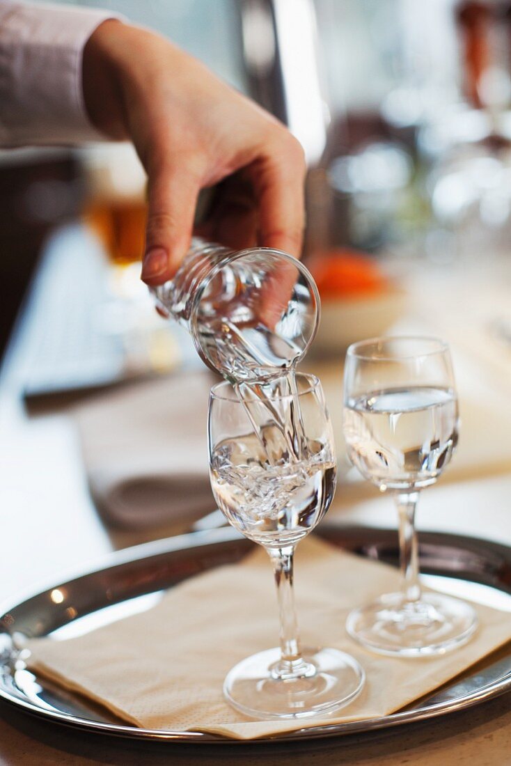 A waitress pouring schnapps into a glass