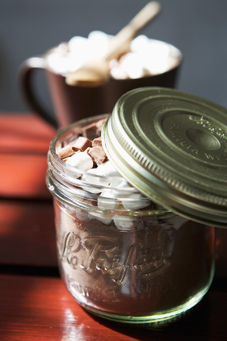 Cocoa powder with marshmallows and chocolate chips in a screw-top jar