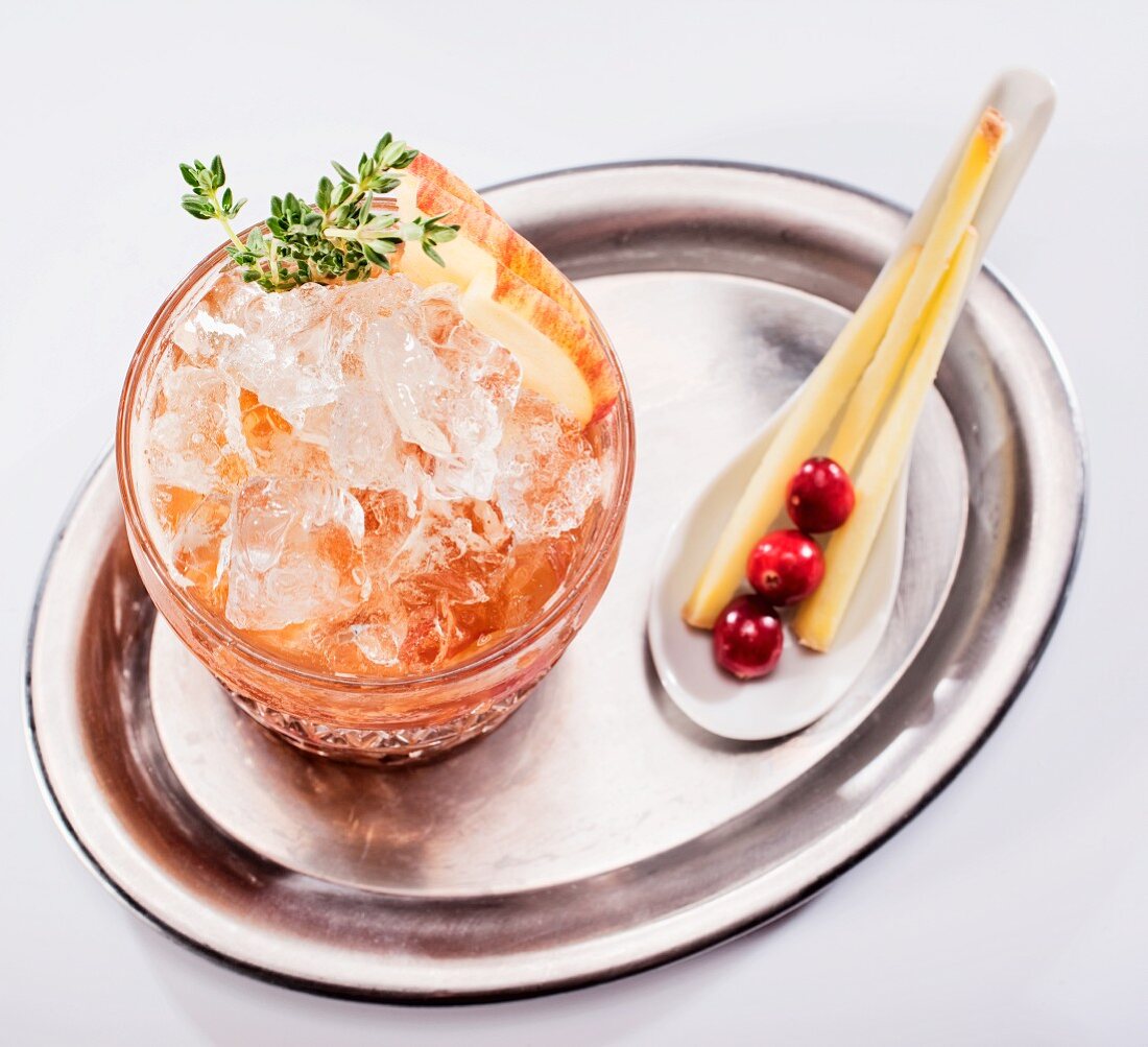 Fruchtcocktail mit Apfel und Cranberries auf Silbertablett