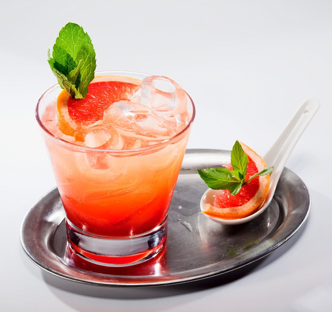 Grapefruit-Cocktail mit frischer Minze auf Silbertablett