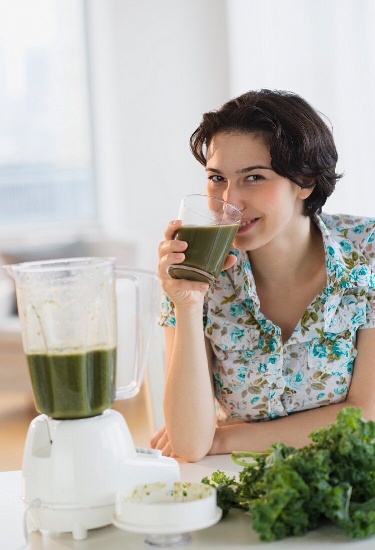 A woman drinking home-made kale juice