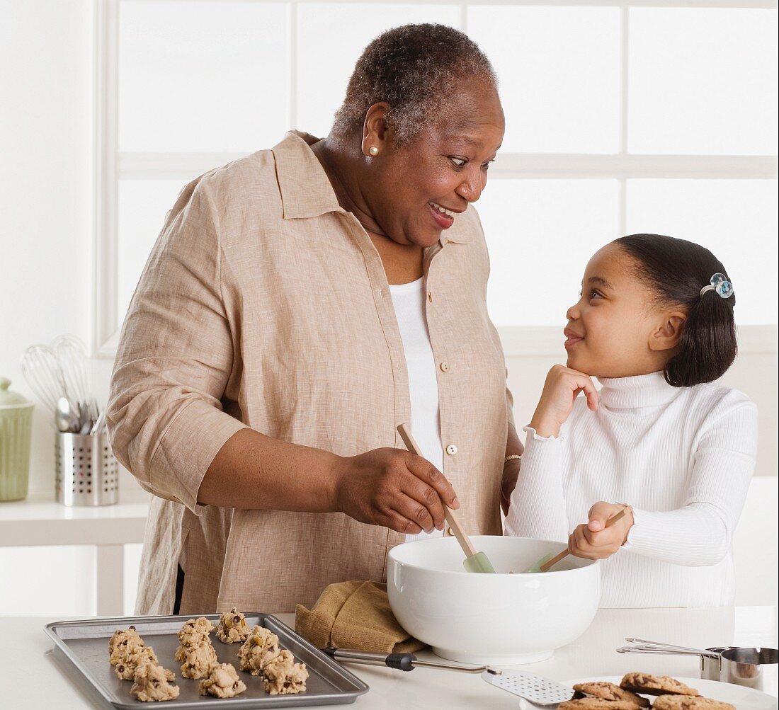 Senior woman making cookies with her granddaughter