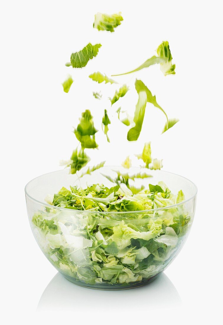 Salatblätter fallen in eine Schüssel