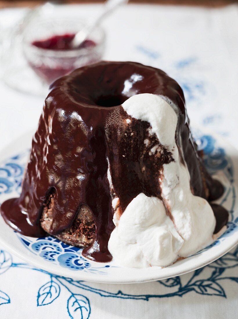 Mohr im Hemd (chocolate pudding decorated with whipped cream, Austria) with chocolate sauce