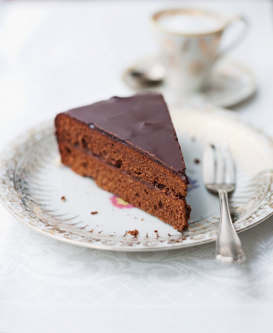 A slice of Sachertorte (rich chocolate cake from Austria) served with coffee