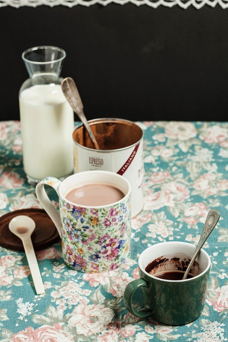 A mug of cocoa, milk and cocoa powder