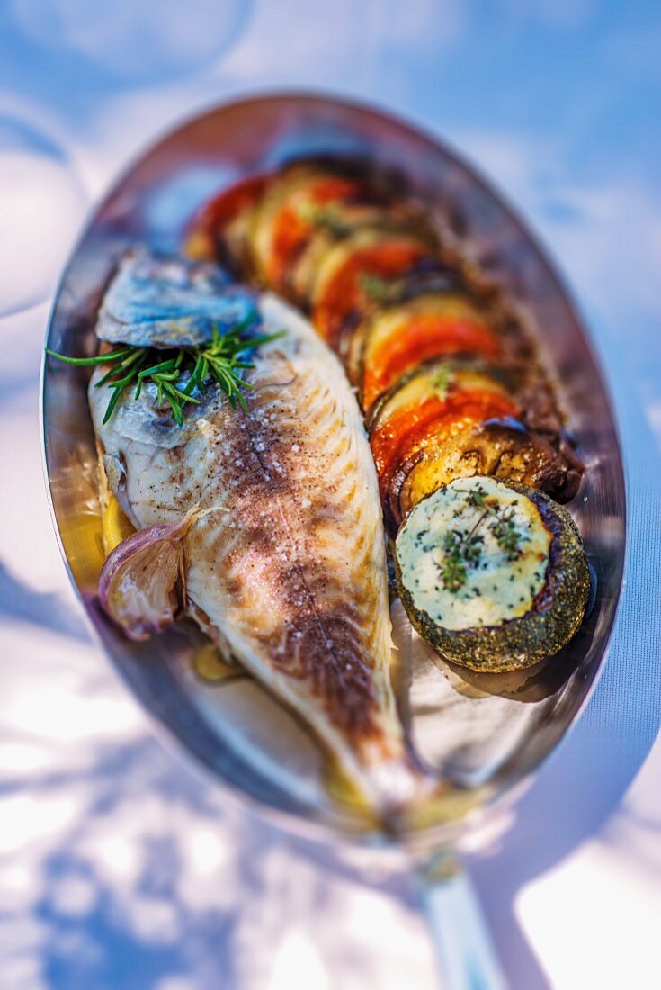 Baked gilt-head bream with aubergines, tomatoes and herb butter