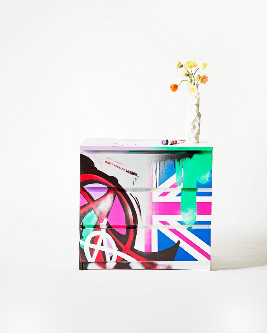 Graffiti symbols and Union flag on front of chest of drawers decorated in two different styles