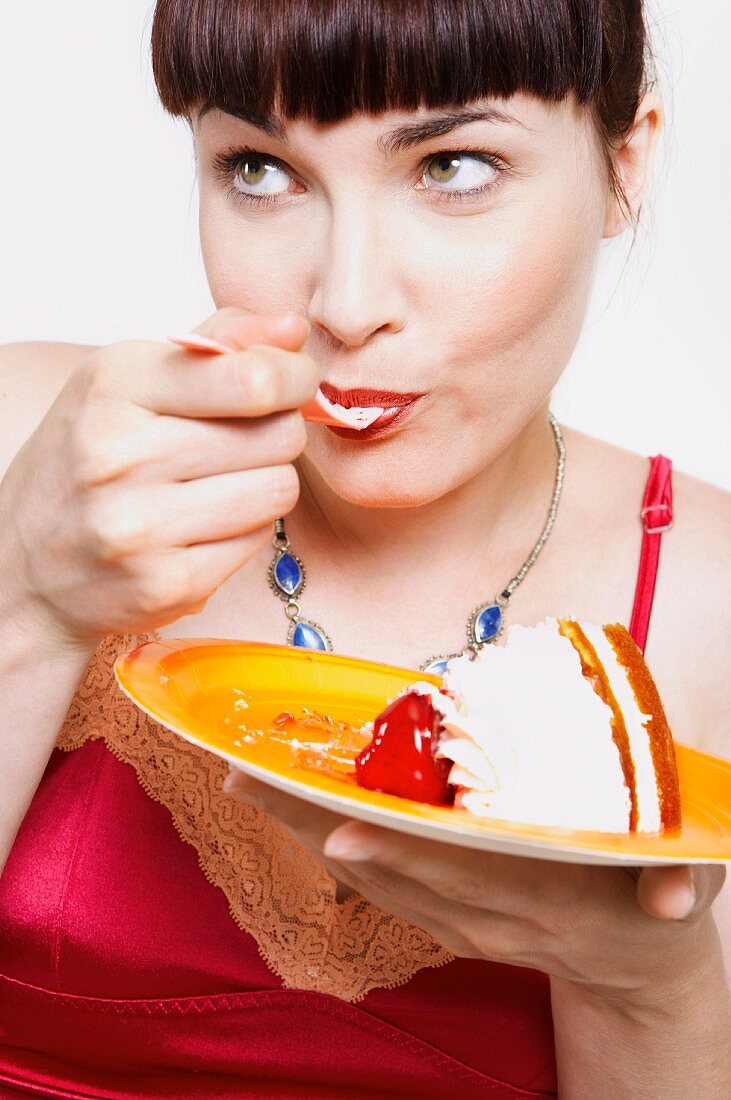 Frau isst ein Stück Torte