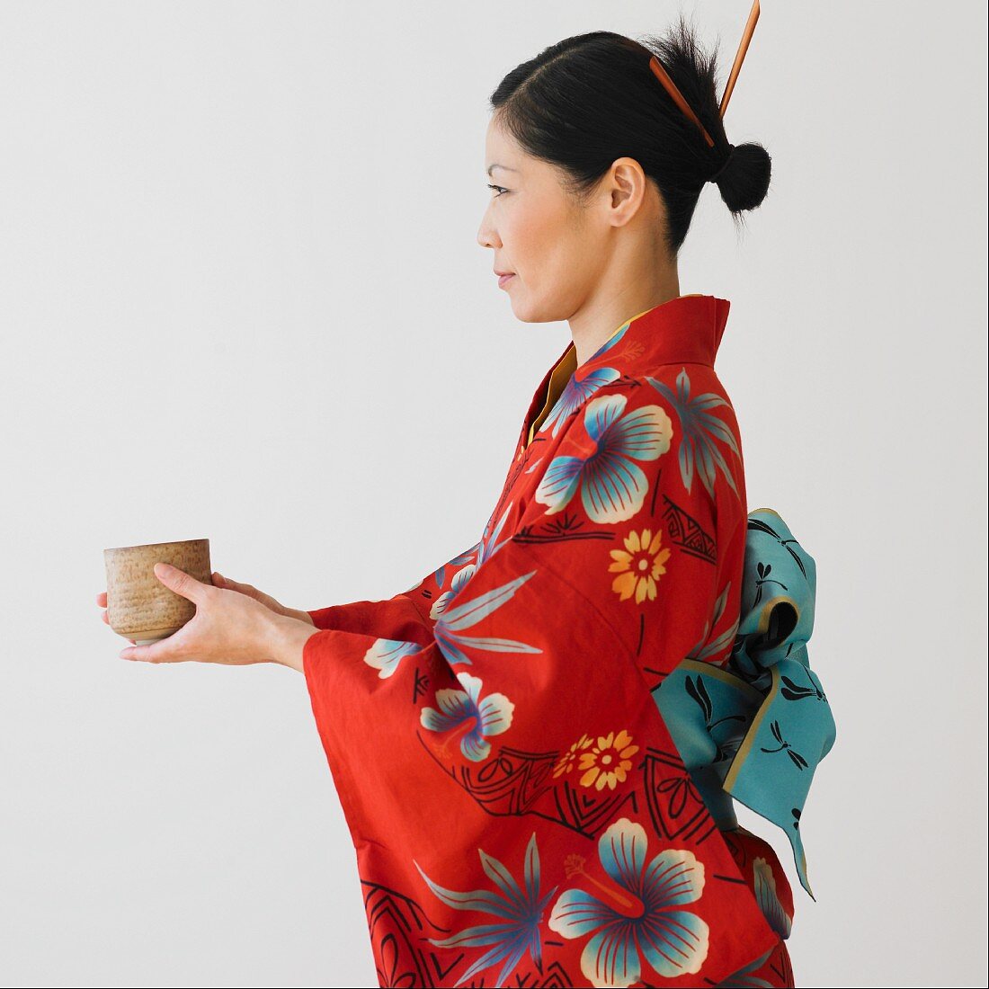 Asian woman in traditional dress holding bowl