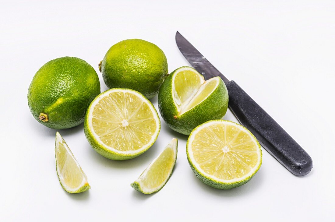 Fresh limes and knife in white background