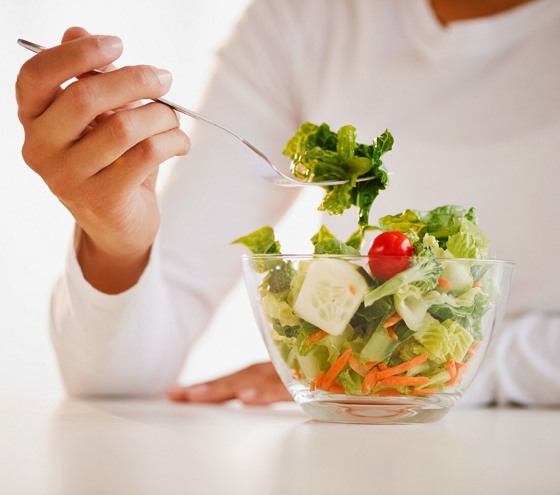 Frau isst gemischten Salat