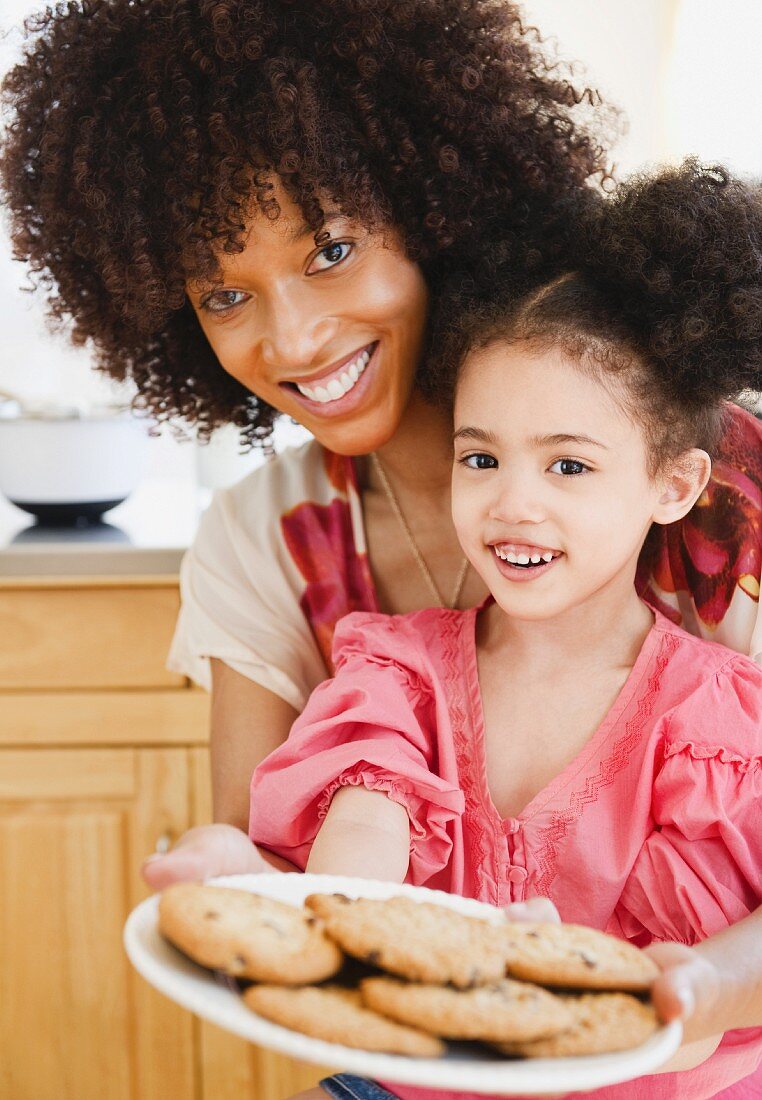 Mother and daughter holding plate of cookies