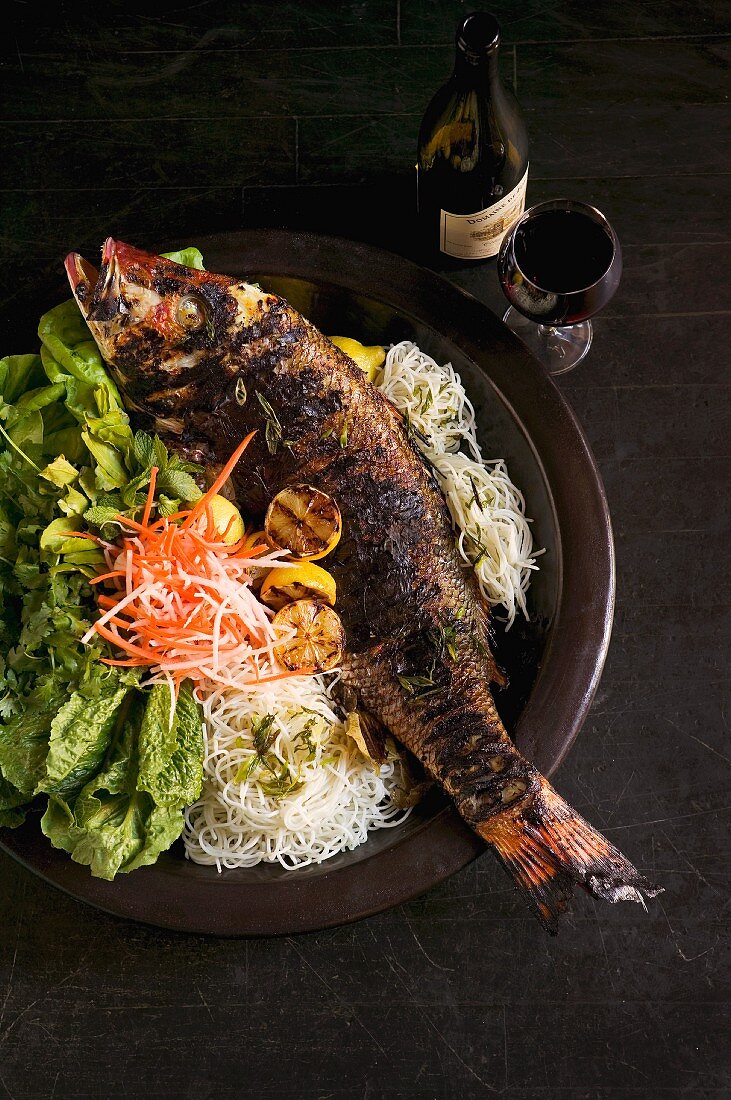 Barbecued sea bass with noodles, vegetables and mixed lettuce