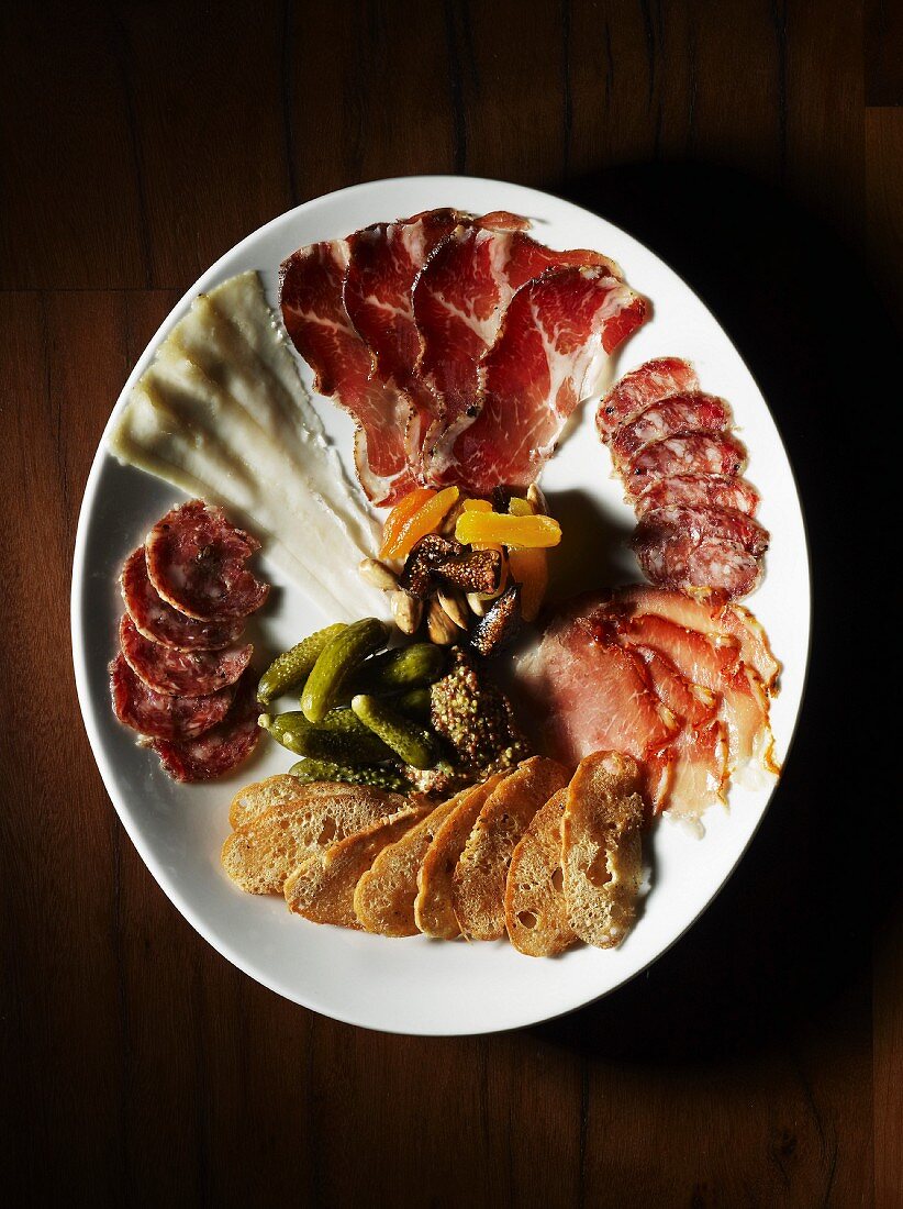 A platter of antipasti with ham, salami and pickles