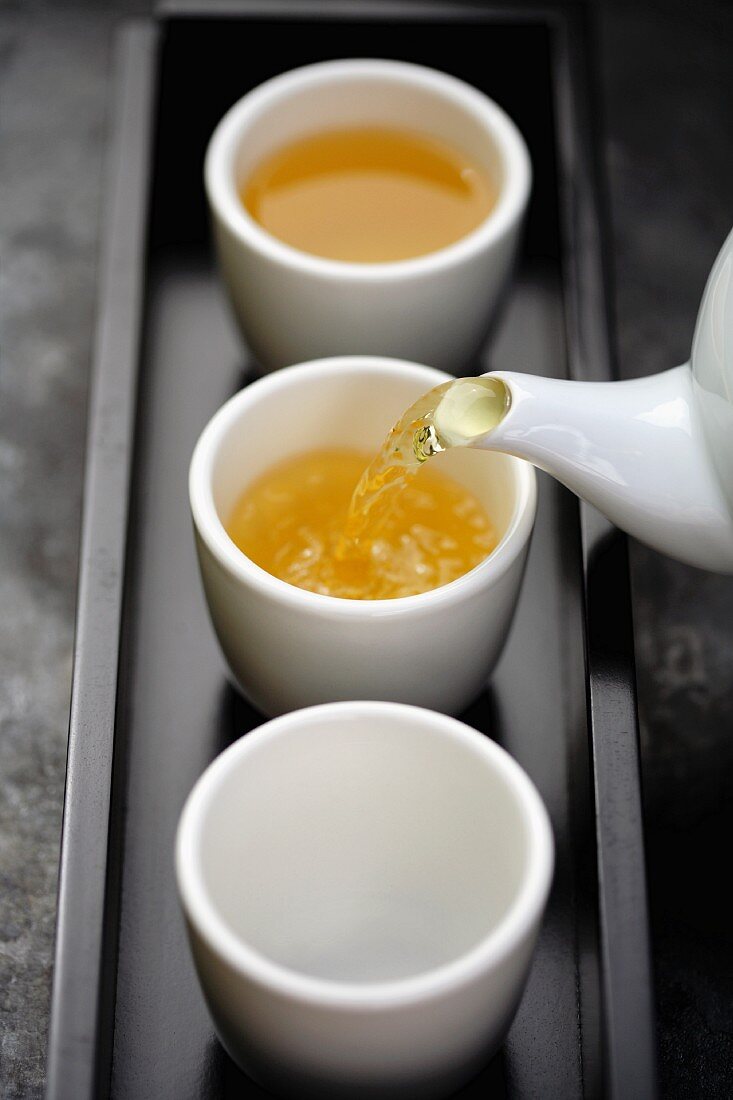 Grüner Tee wird in Teeschälchen gegossen