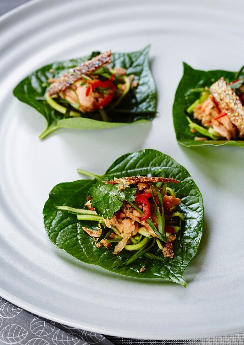 Räucherforelle mit Chilischoten auf Betelblättern (Asien)