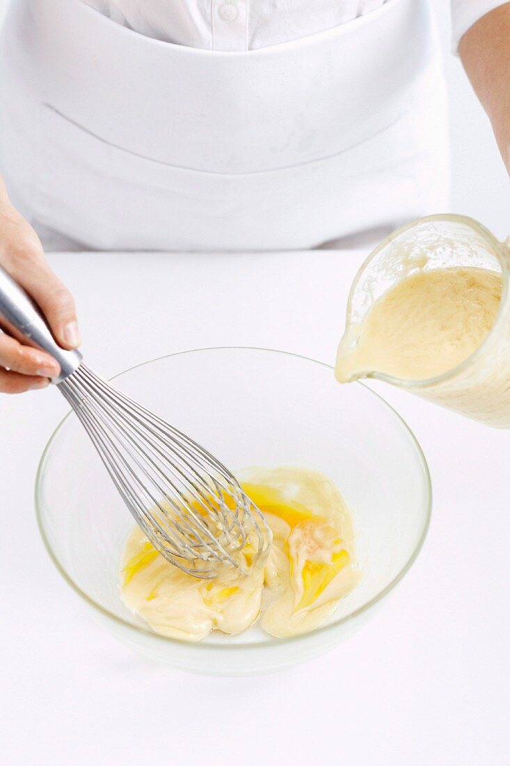 Curdled mayonnaise being whisked with egg yolk
