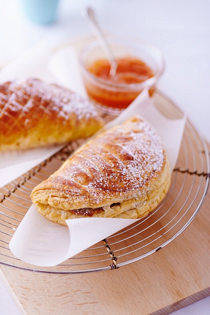 Apple turnovers with icing sugar and jam