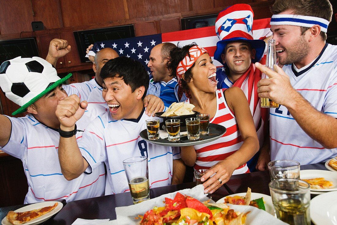 Sportliche junge Leute beim Feiern in einer Bar