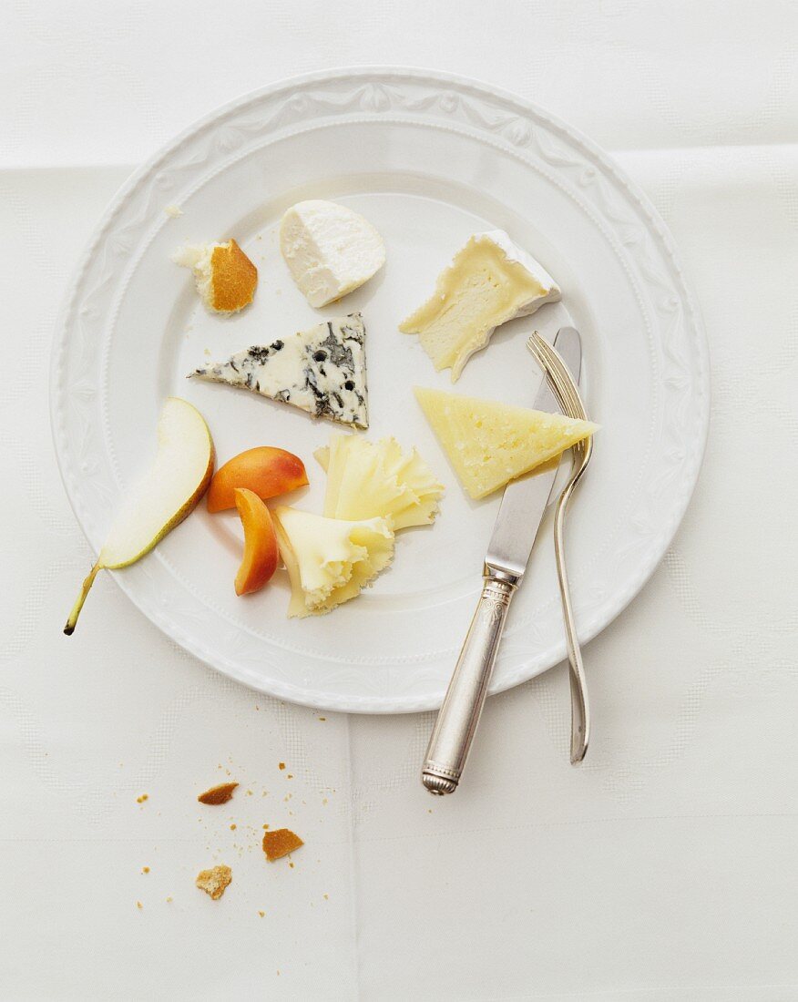 A plate of cheese with assorted varieties of cheese and fruit (view from above)