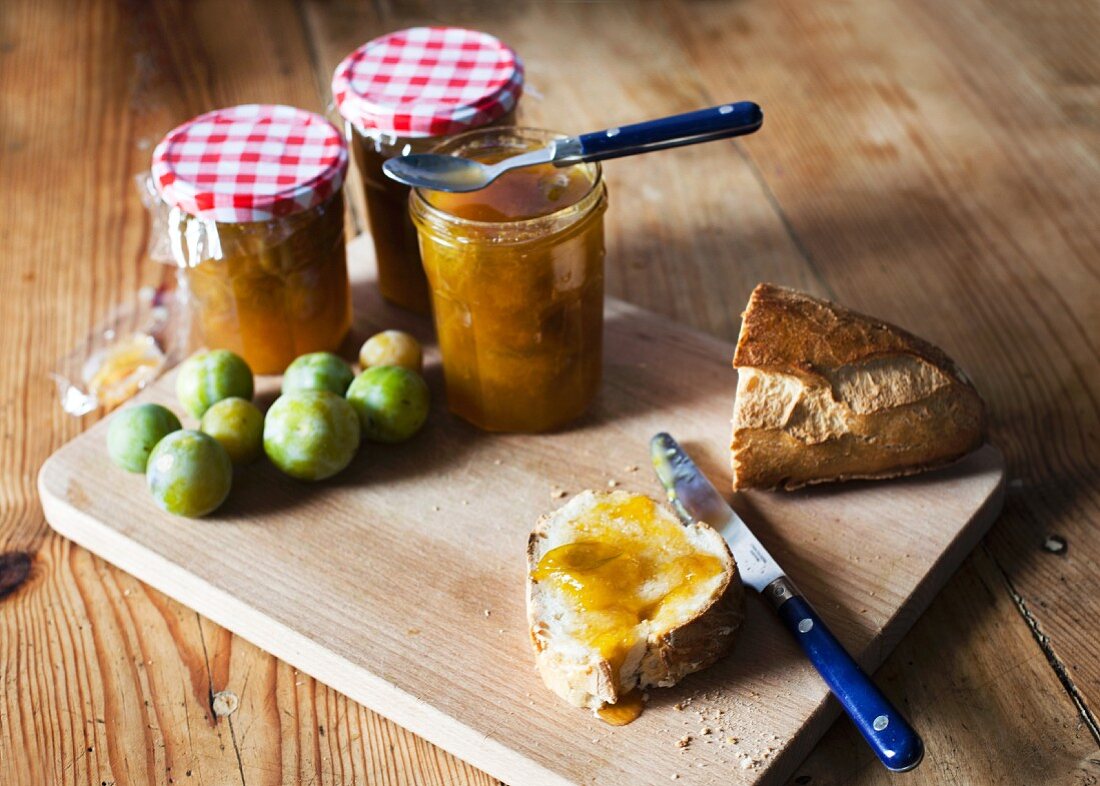 Reineclaudenmarmelade und Brot auf Schneidebrett