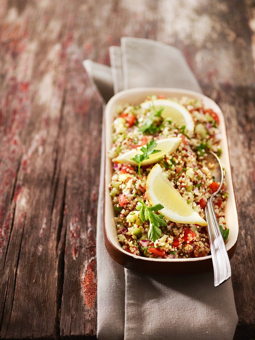 Bulgur salad with cucumber, onions, tomatoes, parsley and lemon wedges