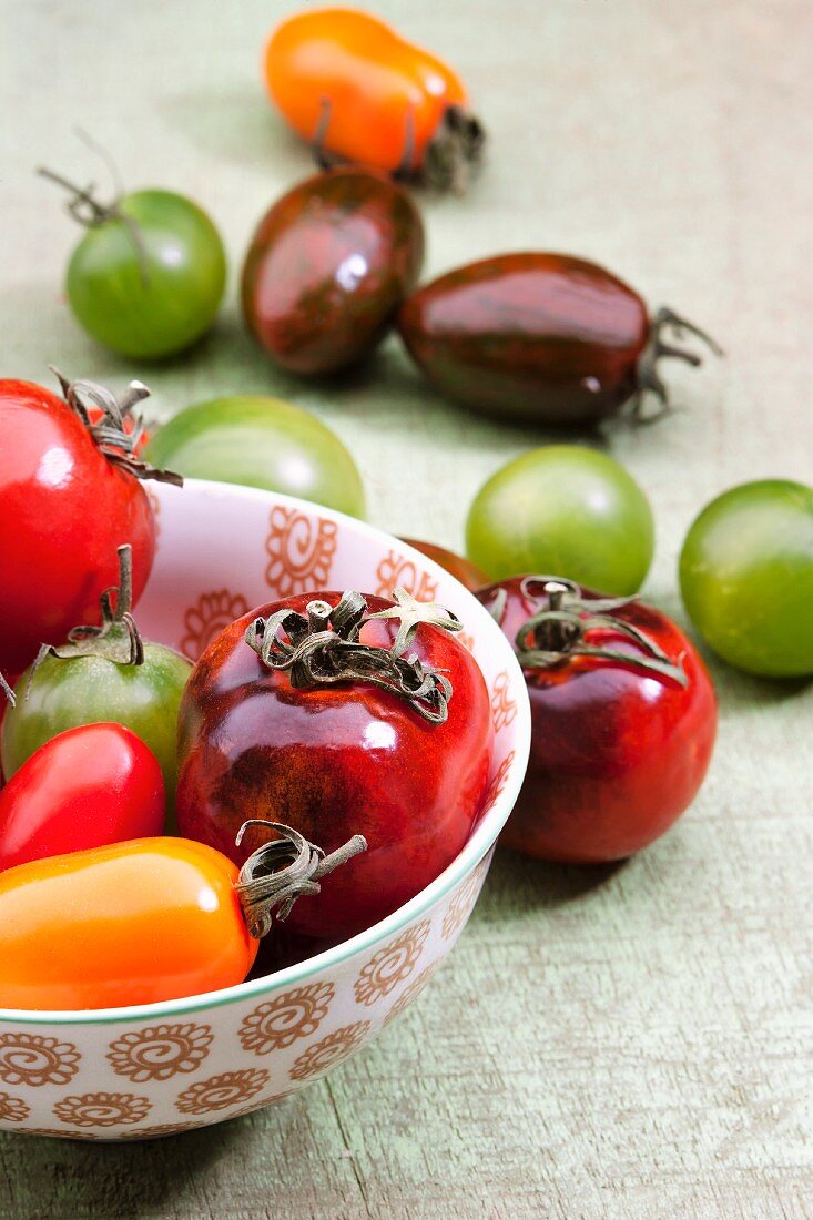 Colourful tomatoes, some in a bowl