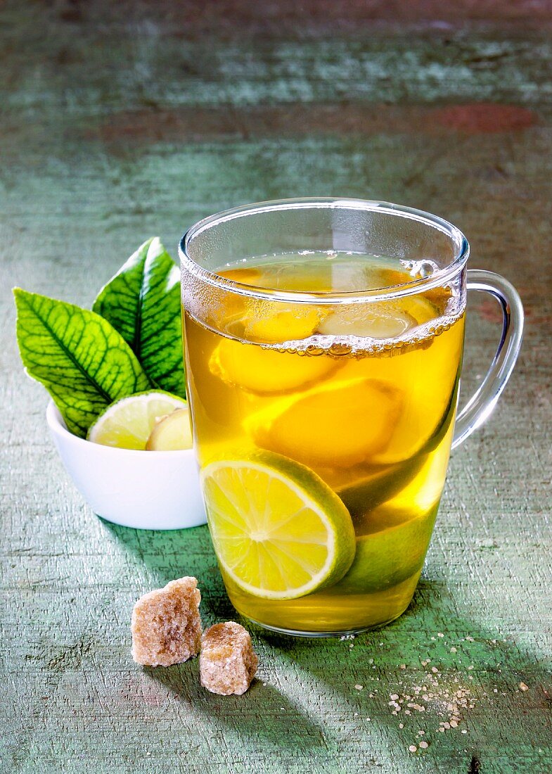 Ginger tea with limes in a glass cup