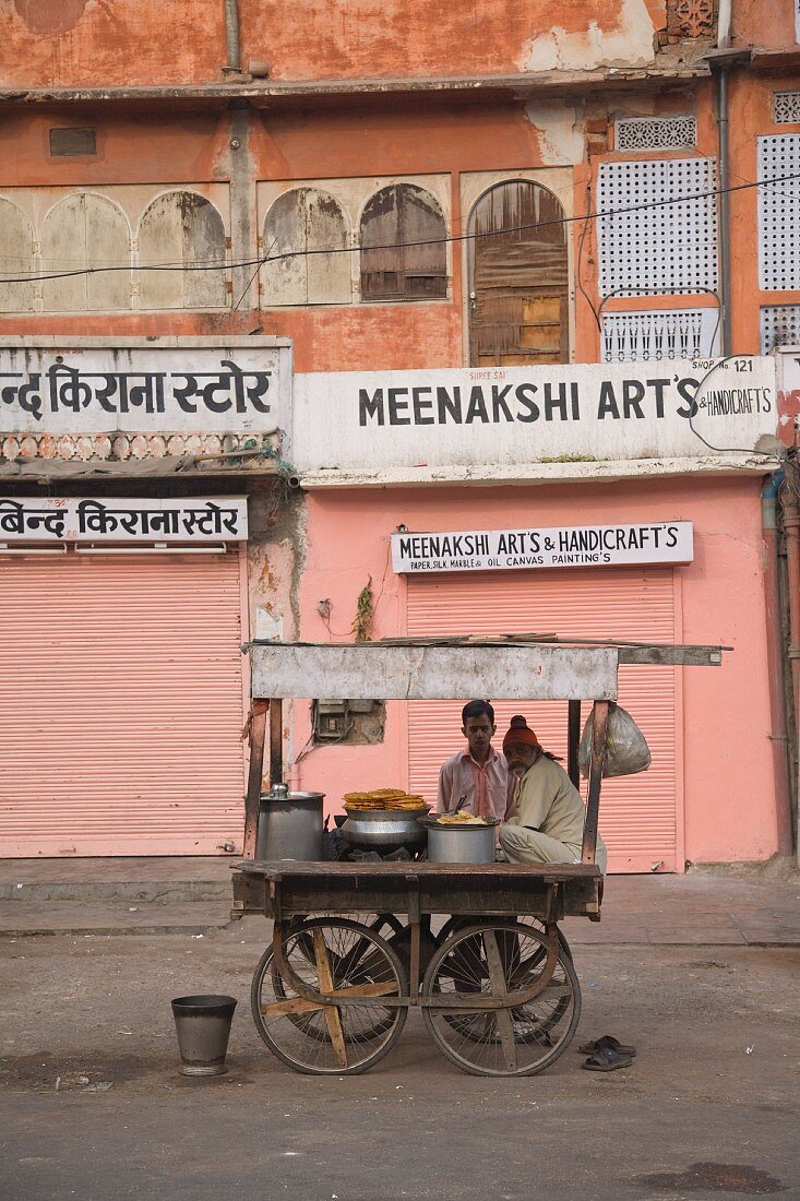 Indischer Imbisswagen vor rosa Hausfassade