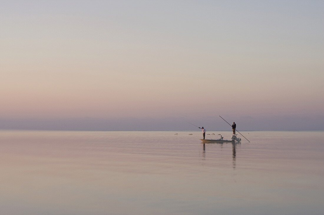 Fischer auf einem Boot im Abendlicht